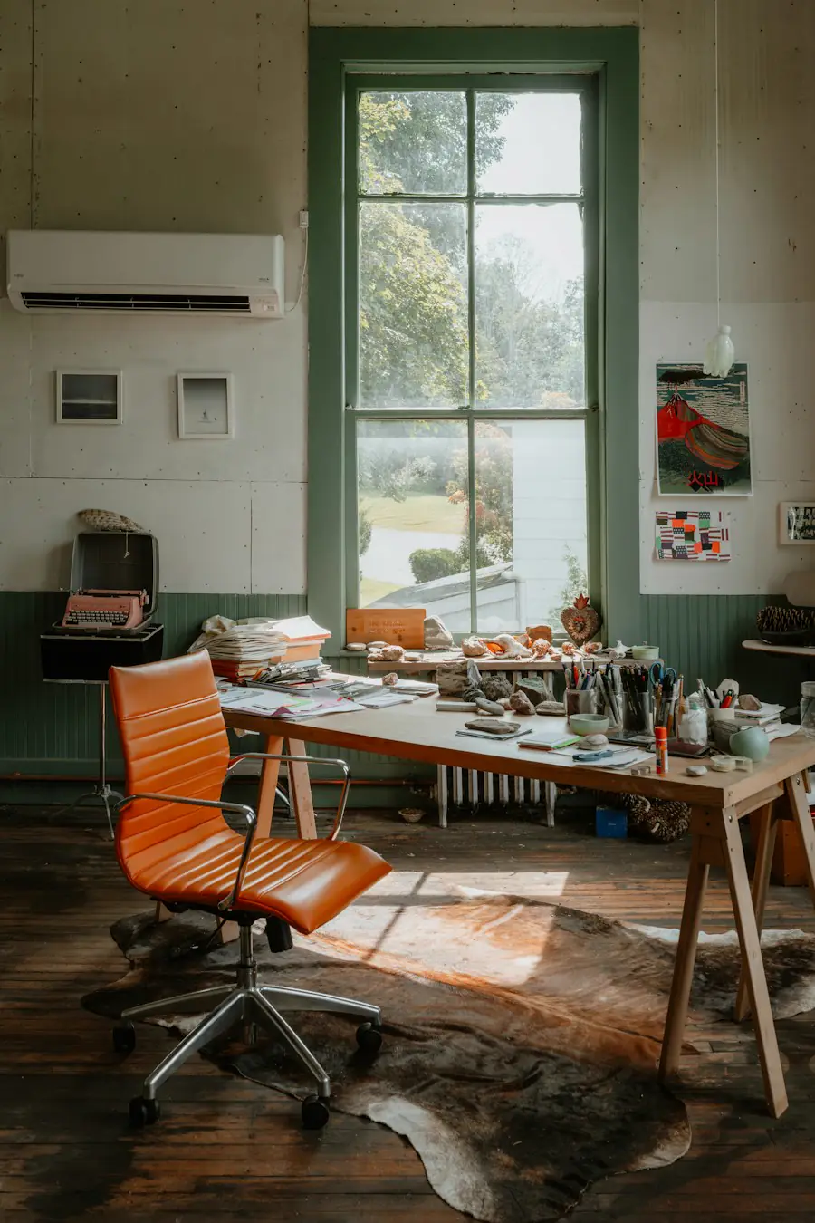 A sunlit independent studio with a worktable and an orange chair.