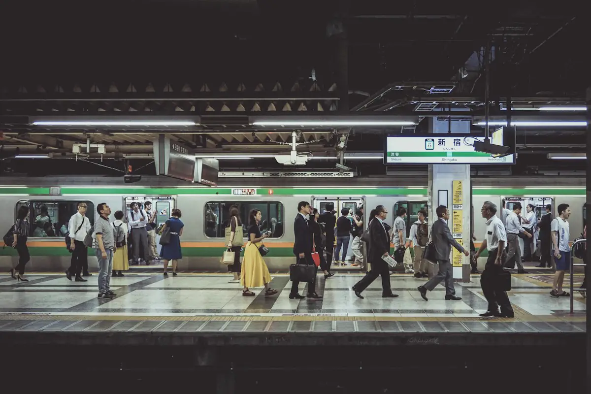 Commuters crossing a train platform in the morning.